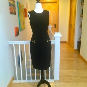 Lovely Calvin Klein black fitted dress, with gold accent pockets.
